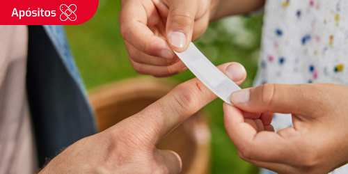 Una persona poniendo un apósito en un dedo Una persona poniendo un apósito en un dedo